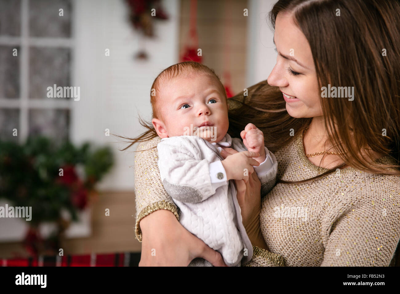 Young mother holding baby son and smiling Stock Photo