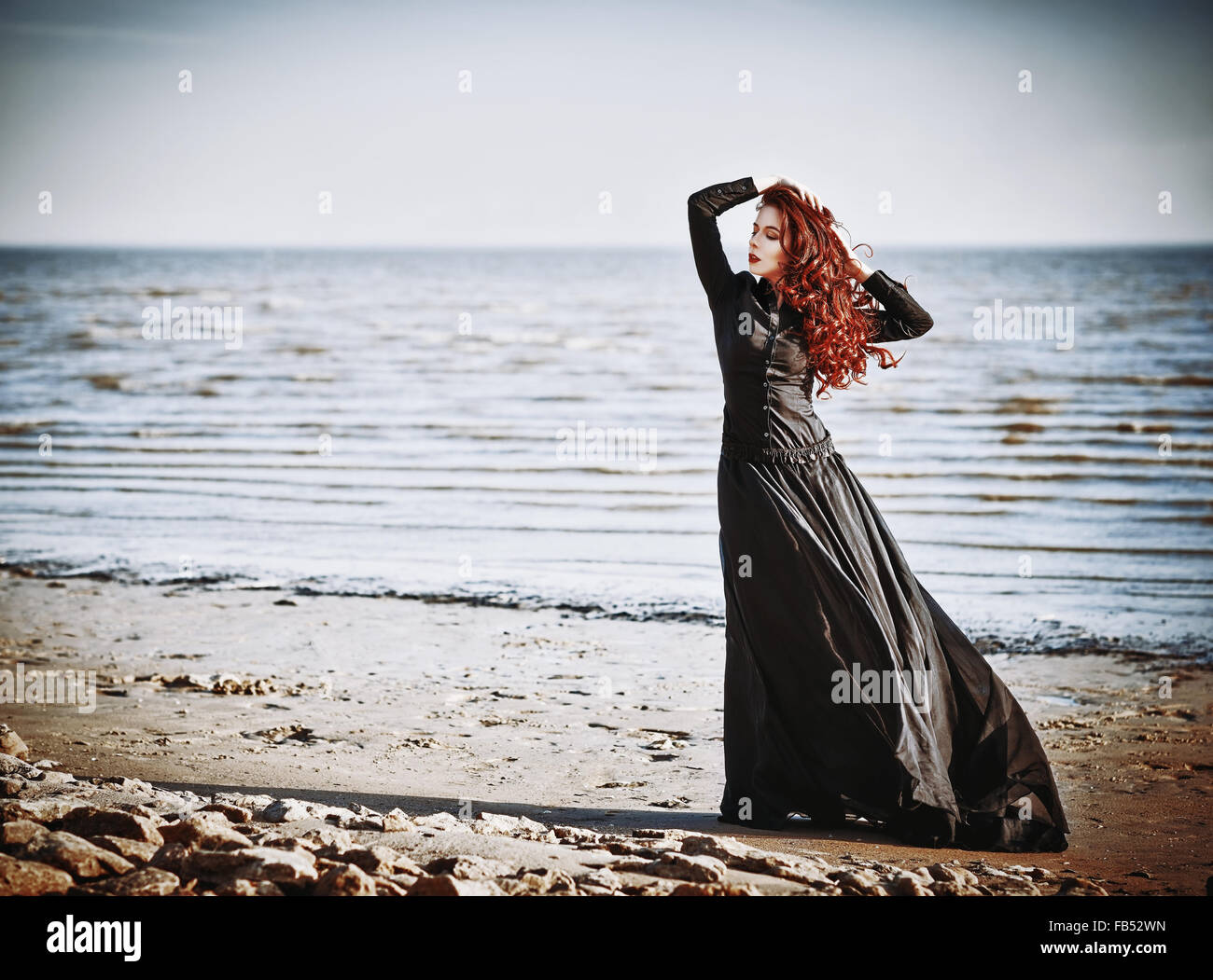 Beautiful sad goth girl standing on the sea beach Stock Photo - Alamy