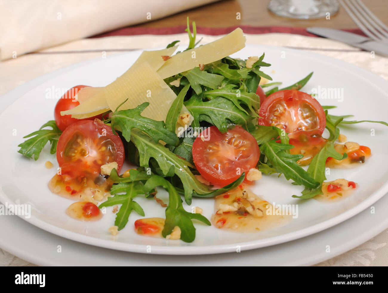 Spicy salad of arugula and cherry tomatoes with parmesan sauce Stock Photo