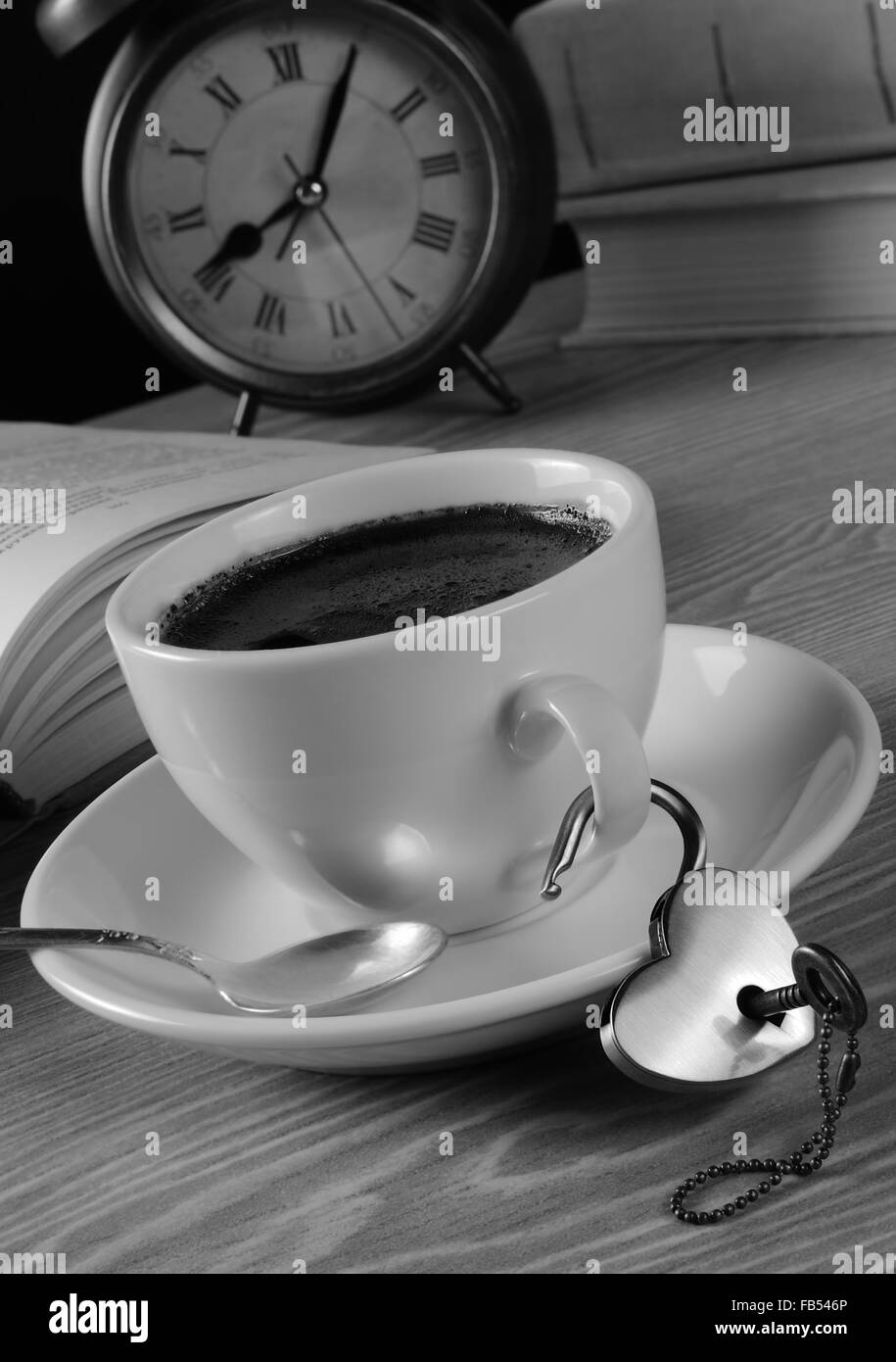 Heart shaped lock and key hanging on the handle of a cup of coffee Stock Photo