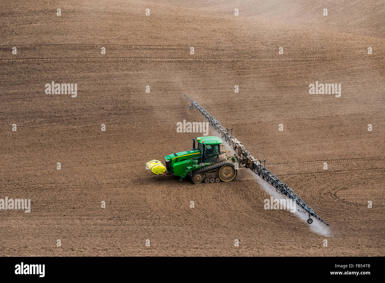 John Deere track tractor configured with spraying booms spraying fertilizer  on a garbonzo bean seedbed in the Palouse region of Stock Photo - Alamy