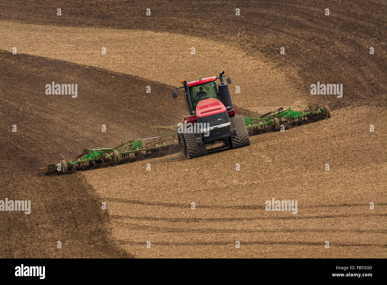 Case track tractor tilling a field with a cultivator in the Palouse region of Washington Stock Photo