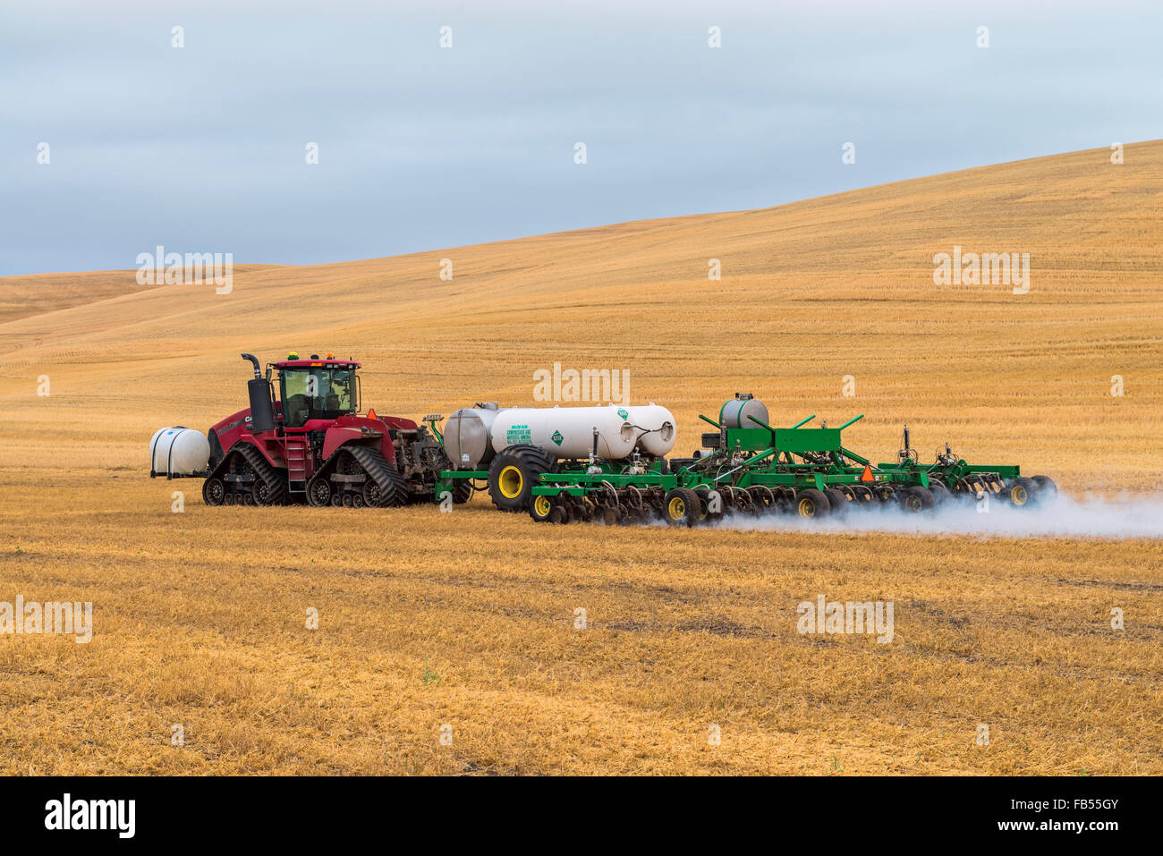 Case quadtrac tractor pulling an anhydrous ammonia tank and applicator applying the anhydrous to a field in advance of preparing Stock Photo