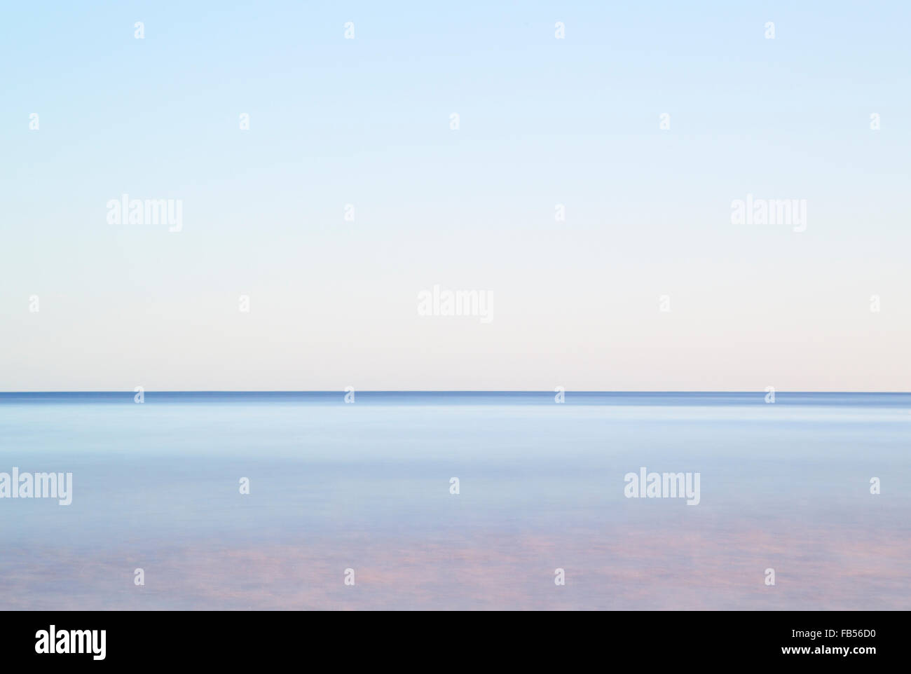 Simplified long exposure semi abstract view of waves over sandy beach concepts peaceful calm horizon distant future Stock Photo