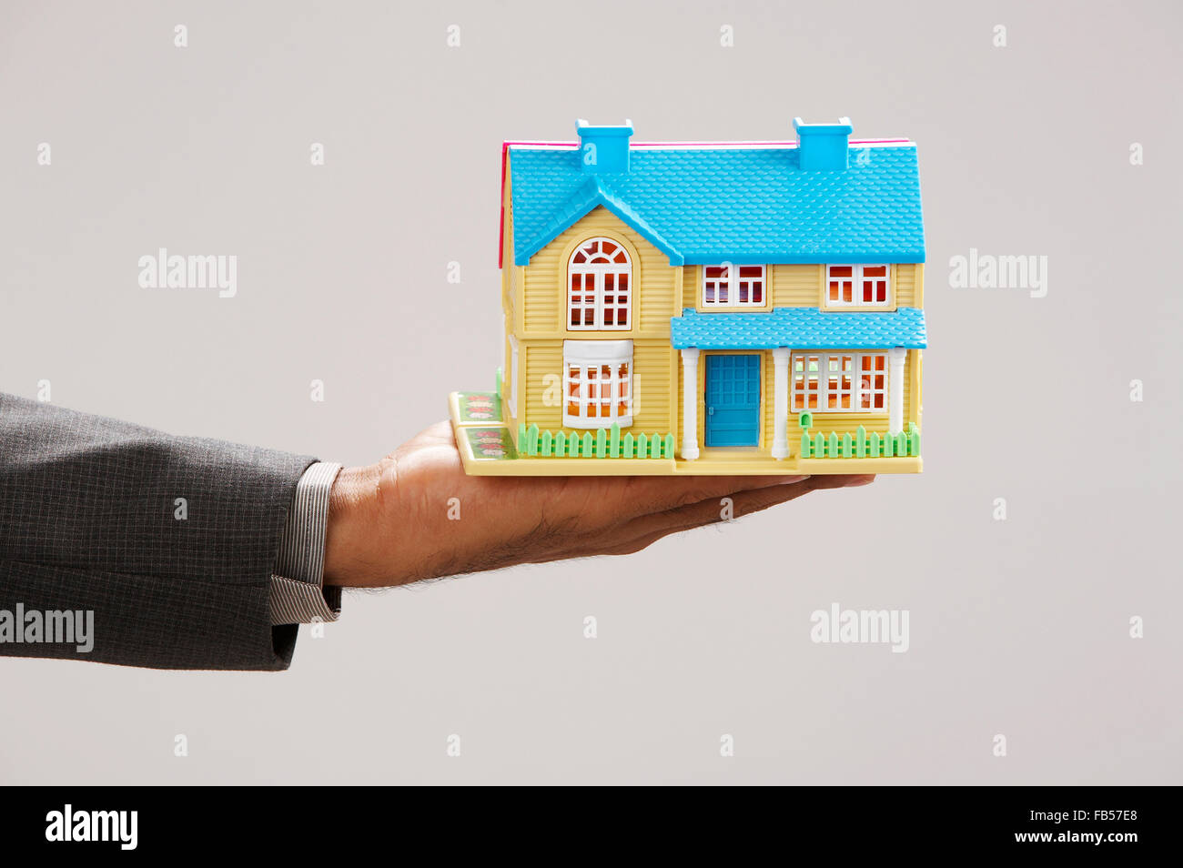 real estate agent holding a model house Stock Photo - Alamy
