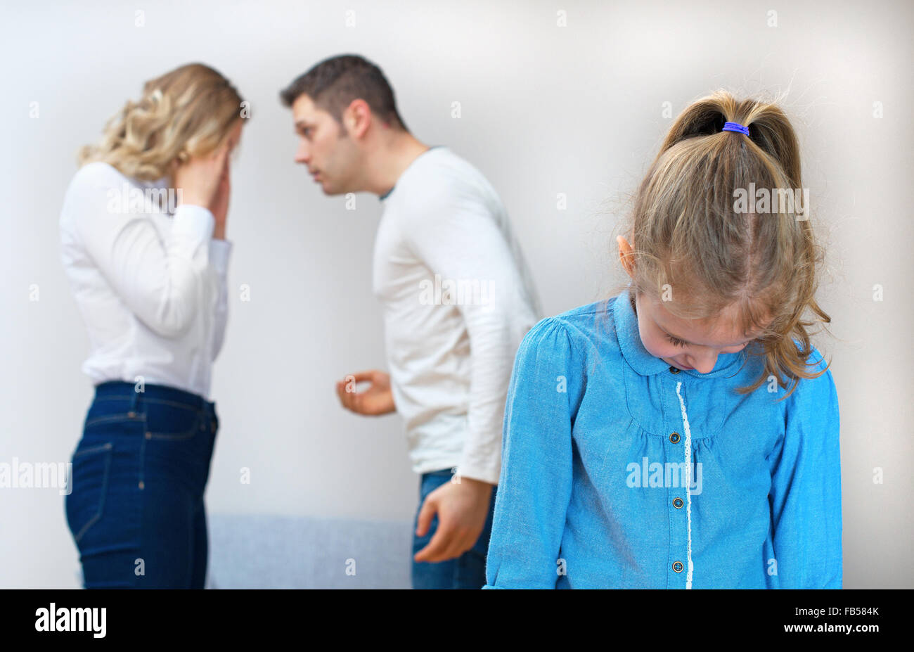 Parents quarreling at home, child in shock. Stock Photo