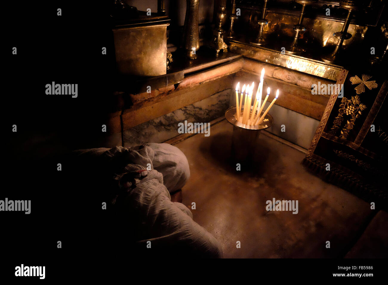 A Christian worshiper prays inside the Aedicule the14th Station of the