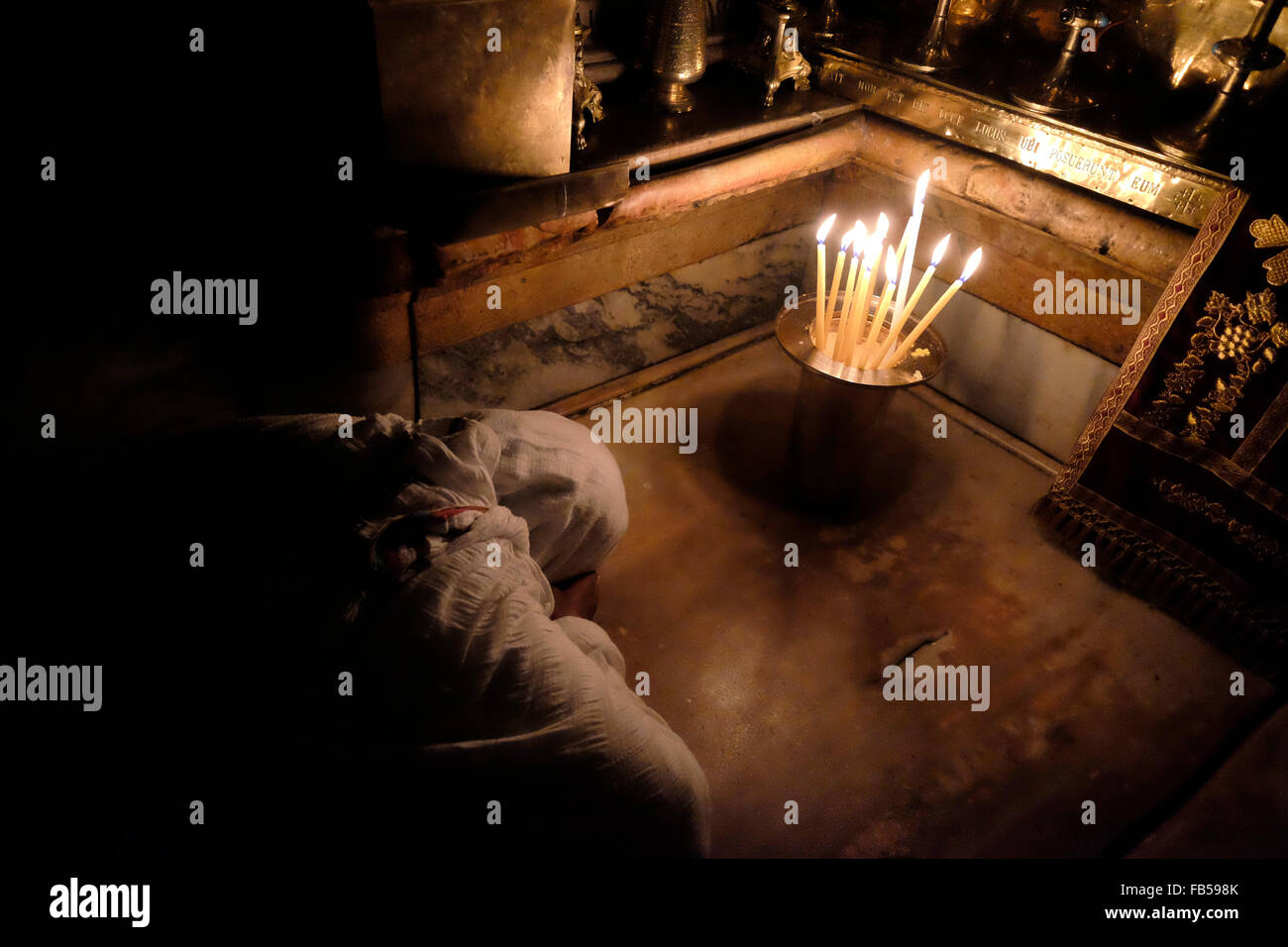 A Christian worshiper prays inside the Aedicule the14th Station of the