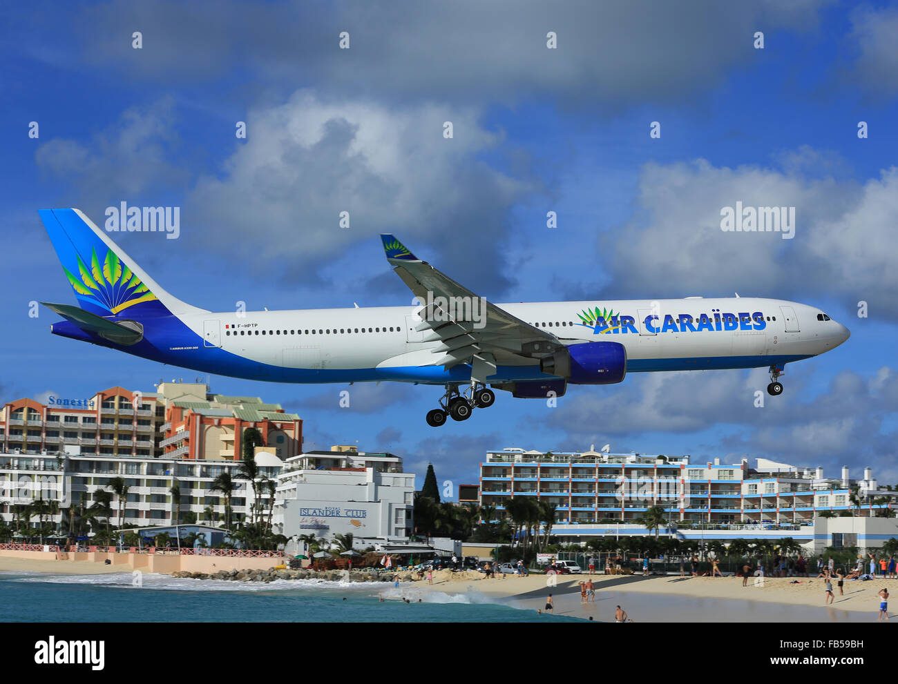 An Air Caraibes, Airbus A.330 arriving over Maho Beach to land at Princess Juliana Airport, Sint Maarten in the Caribbean Stock Photo
