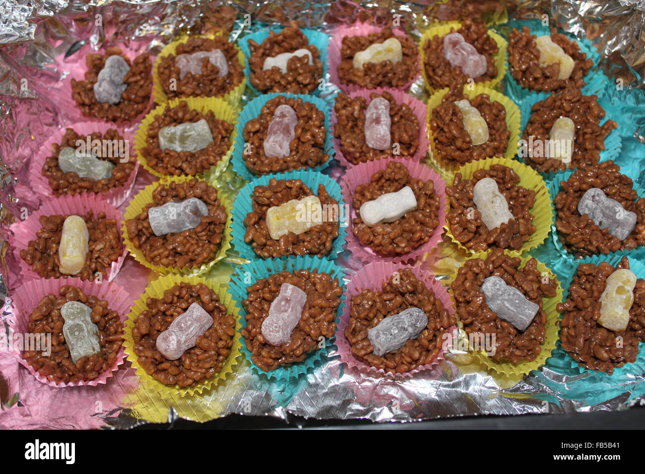 Zombie Cakes: Chocolate crispy cakes with jelly baby decorations and pink, turquoise blue and yellow cases Stock Photo