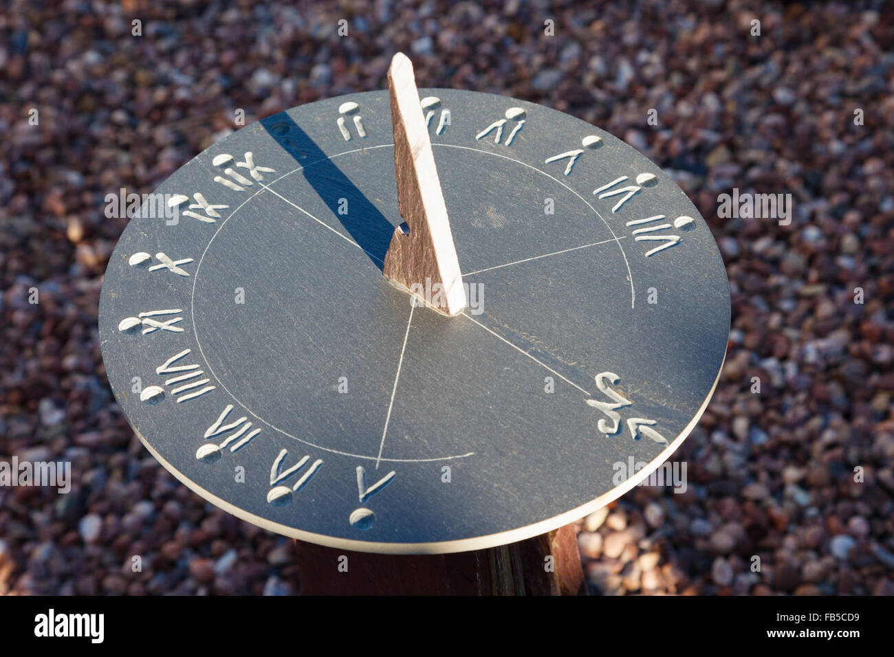 Close up of a garden sundial made from slate showing the time at 1 o'clock in afternoon. UK, Britain Stock Photo