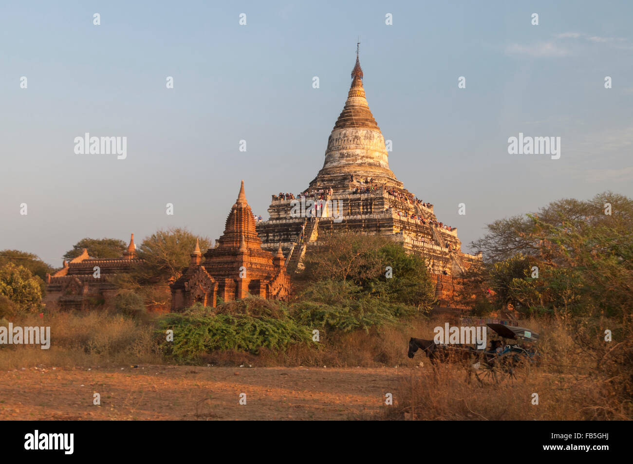 Shwesandaw pagoda in Bagan/Pagan, Mandalay Region, Myanmar, with tourists awaiting sunset. Horse cart in the foreground. Stock Photo