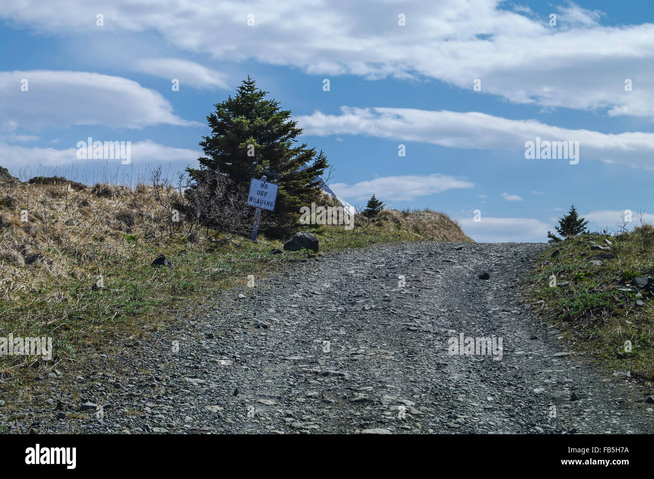 Sign reading 'No off-roading' on side of a gravel road. Stock Photo