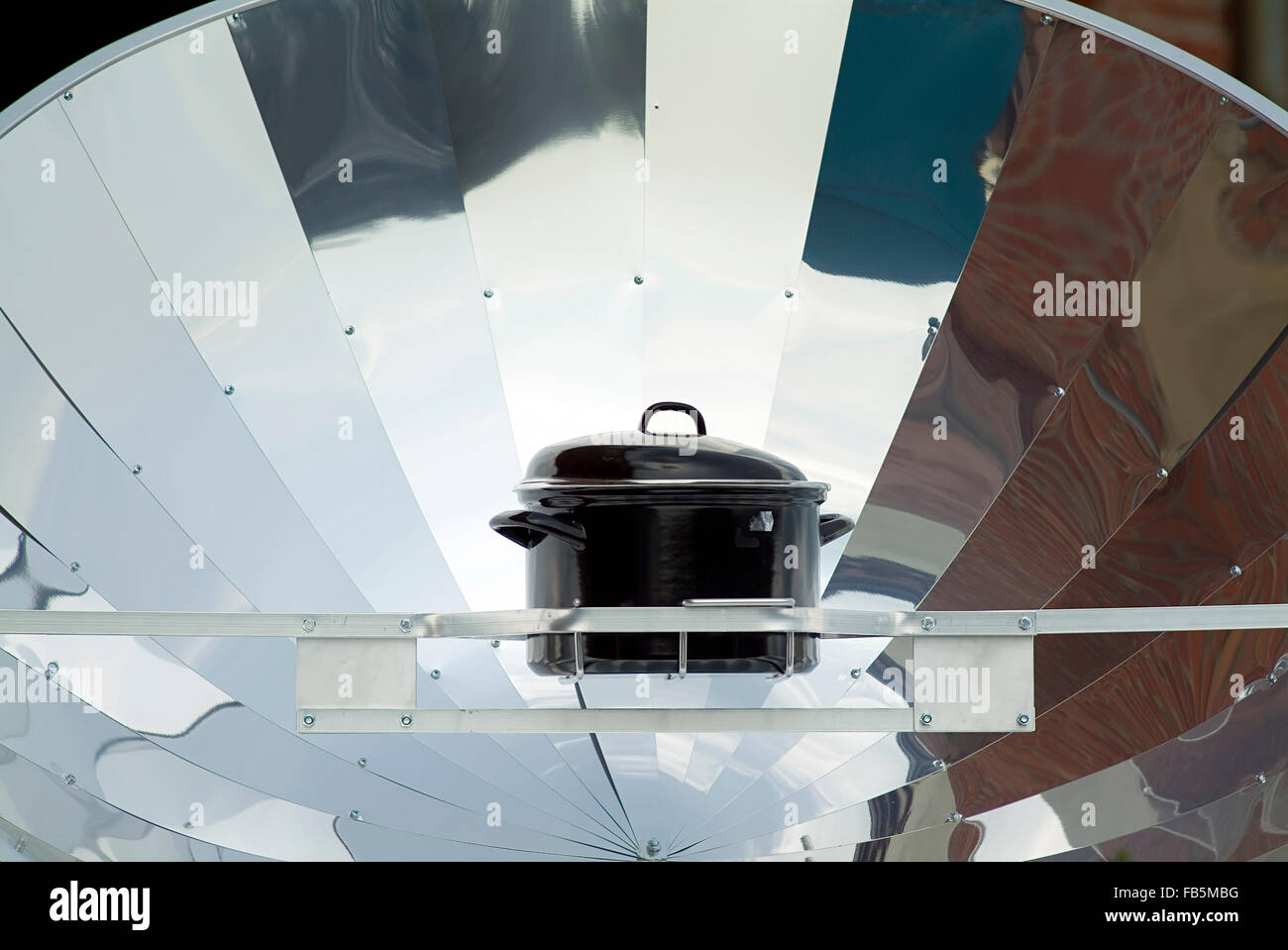 Black pot on a Solar cooker Stock Photo
