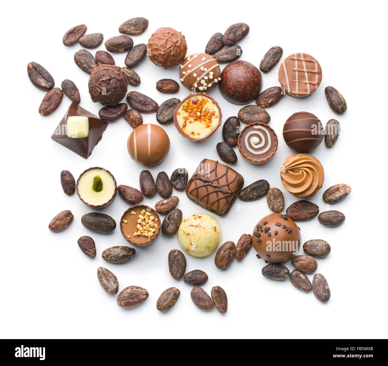 various chocolate pralines and cocoa beans on white background Stock Photo