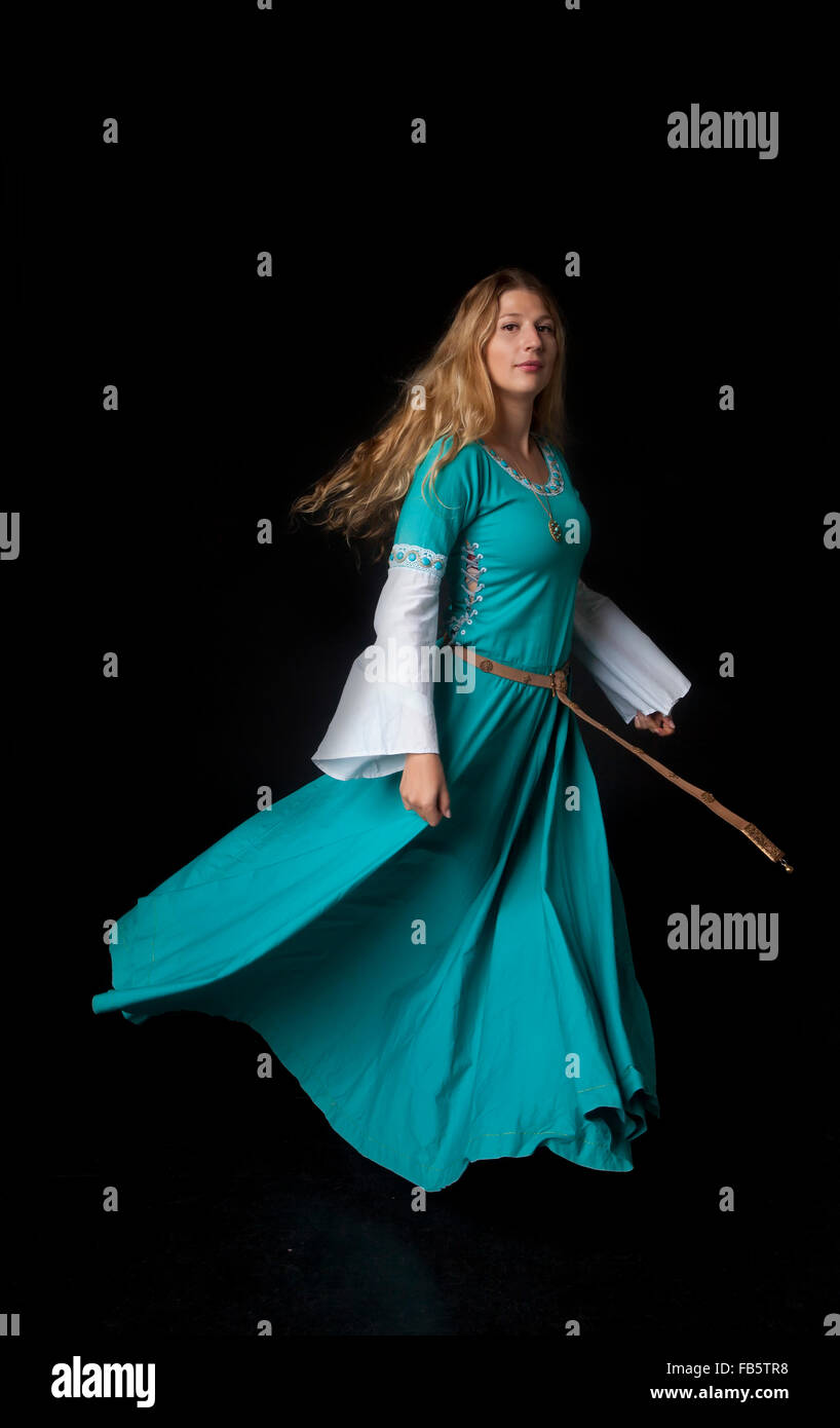 Studio shot of young beautiful girl dancing in a medieval noblewoman costume (on black background) Stock Photo