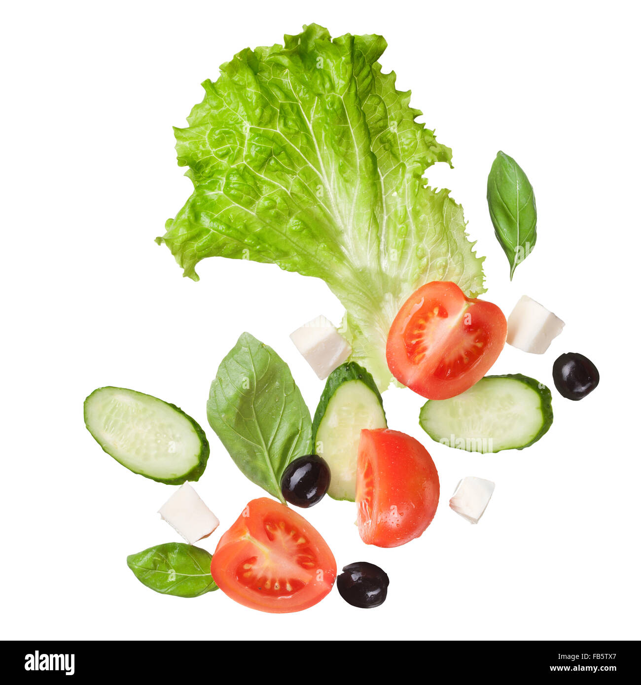 flying salad isolated in white - red tomatoes, pepper, cheese, basil, cucumber and olives Stock Photo