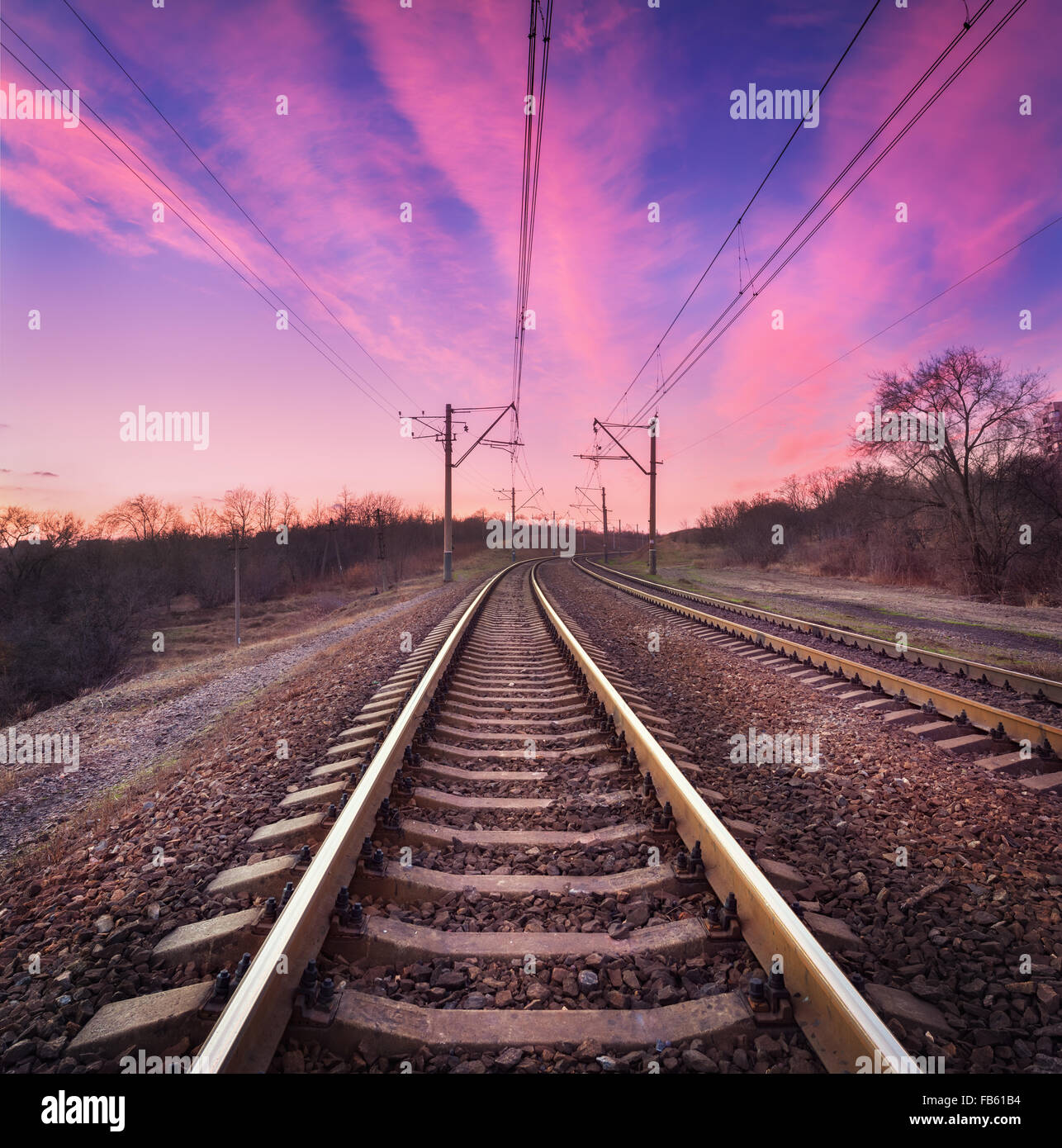 Train platform at sunset. Railroad in Ukraine. Railway landscape. Stock Photo