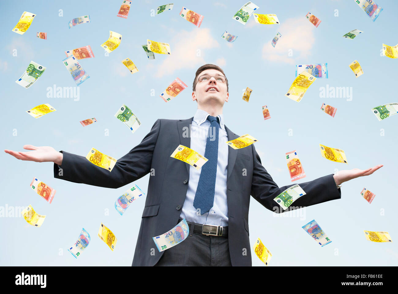 Happy businessman standing in the rain of  money Stock Photo