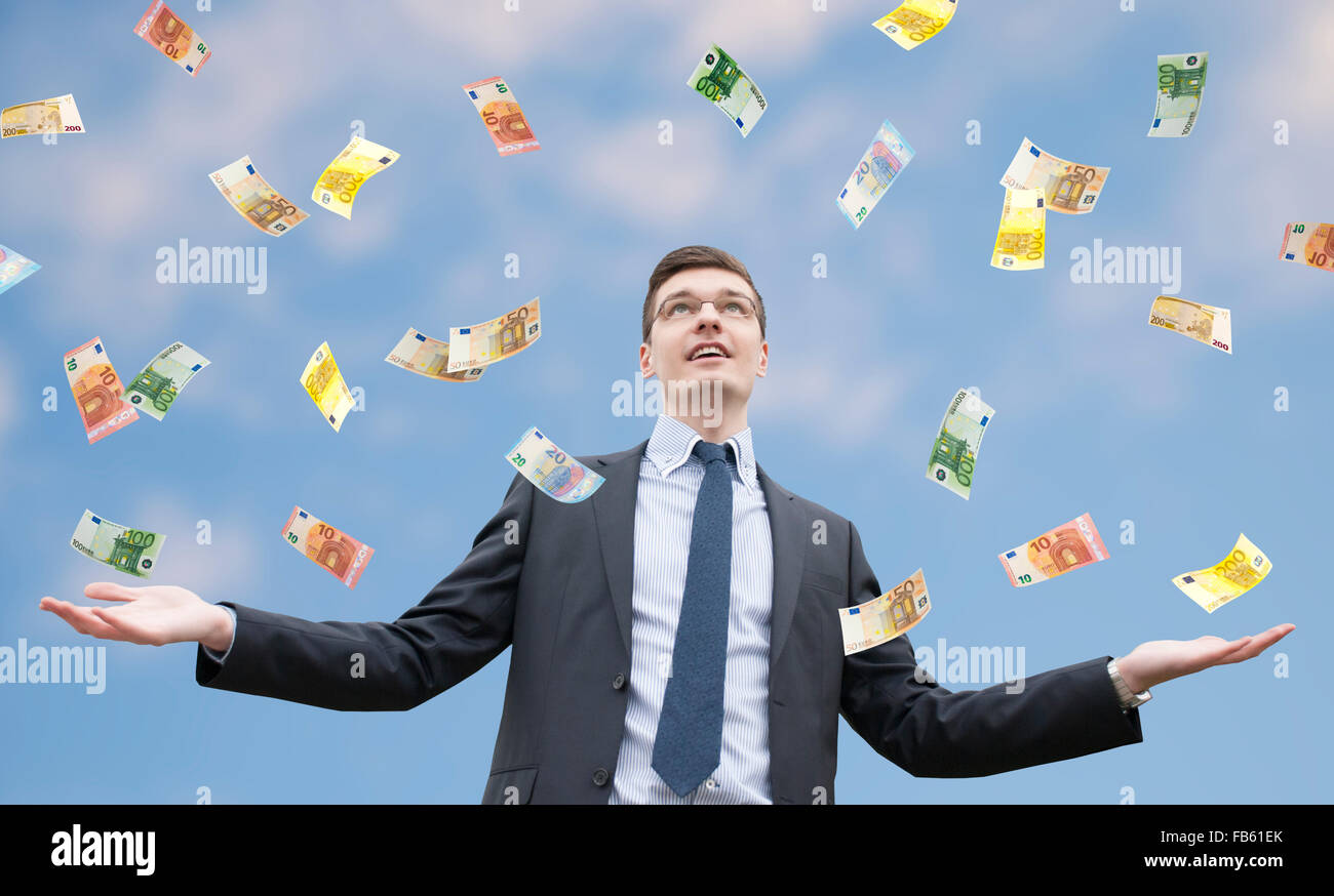 Happy businessman standing in the rain of  money Stock Photo