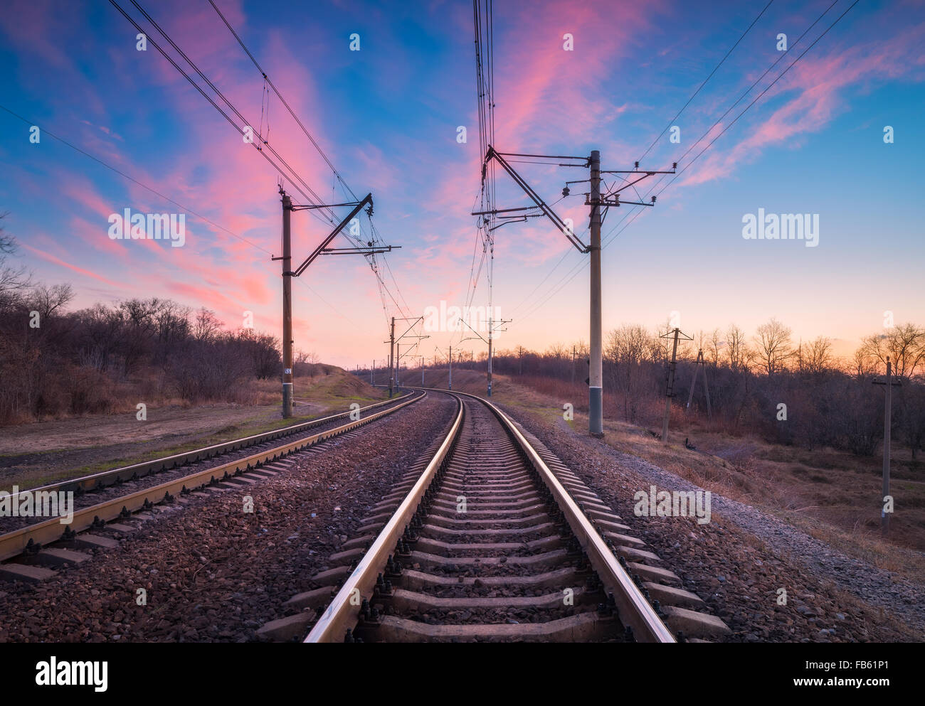 Train platform at sunset. Railroad in Ukraine. Railway landscape. Stock Photo