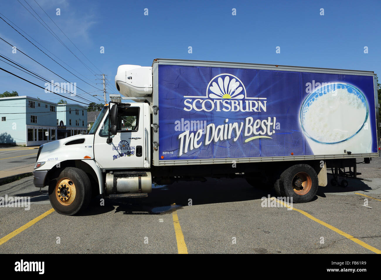 A delivery truck in a parking lot at Mahone Bay in Nova Scotia, Canada. The advert on the side is for dairy produce. Stock Photo