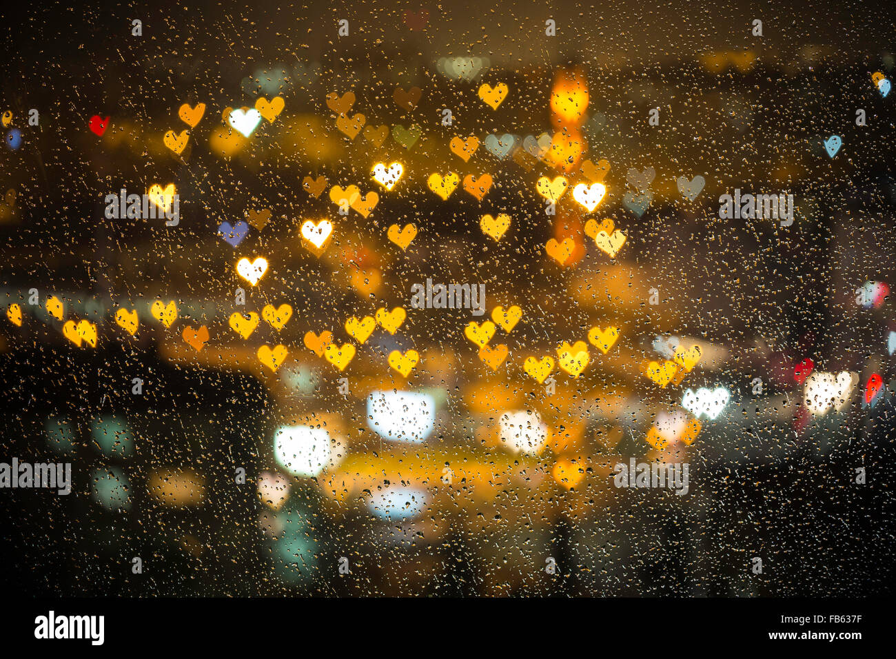 Small colorful hearth bokeh behind the wet glass for valentine day love concept background Stock Photo