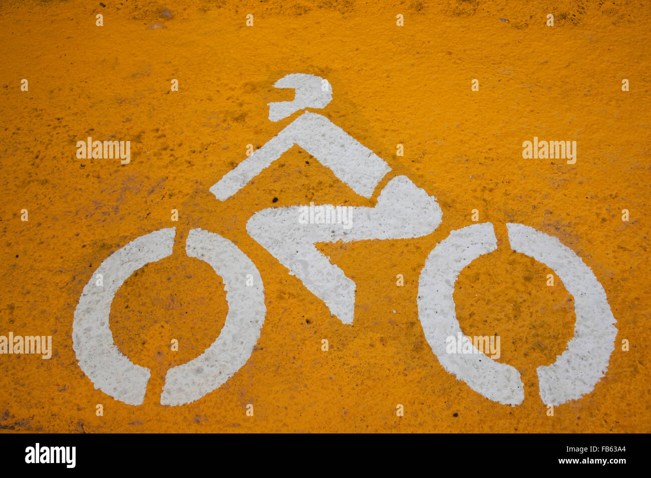 Pictogram on the road, motorbike with driver, biker, white on yellow background, Lisbon, Portugal Stock Photo