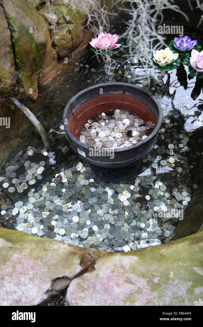 Wishing well pond with silver coins underwater Stock Photo