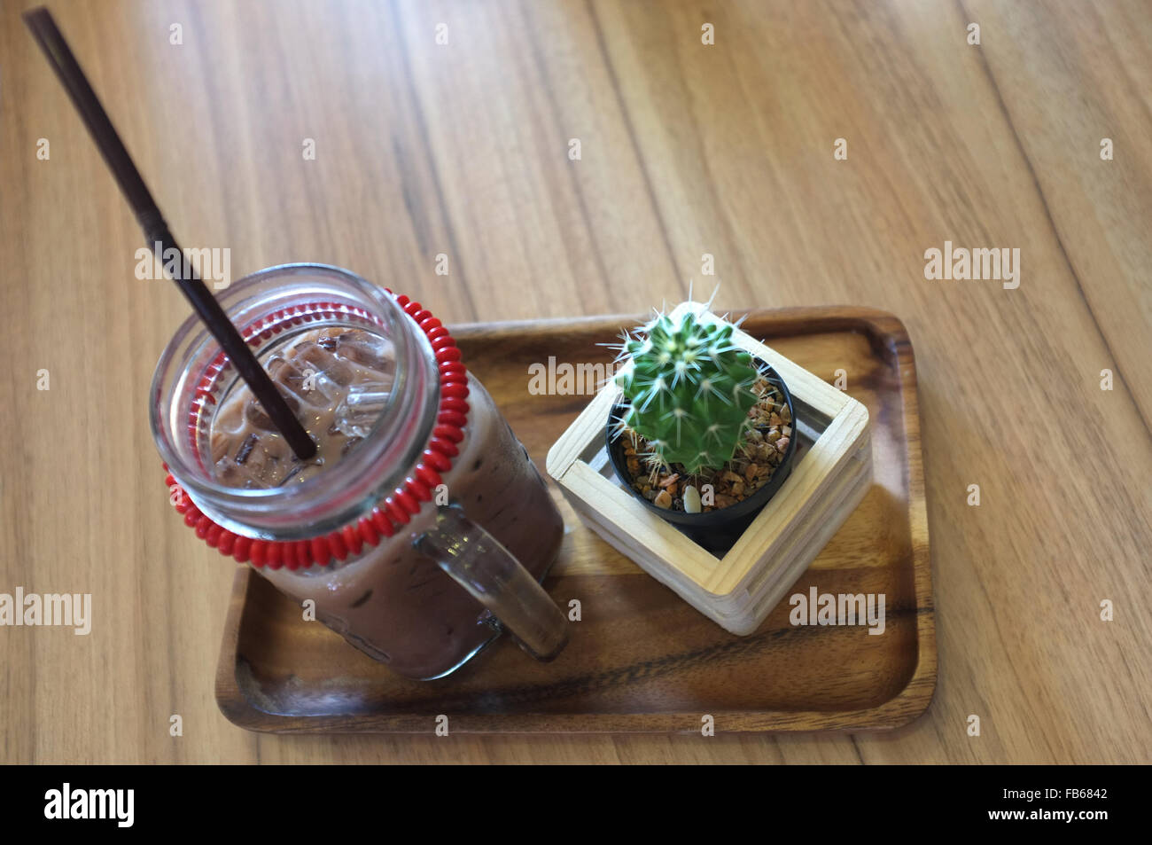 Ice coffee and cactus on wooden table Stock Photo
