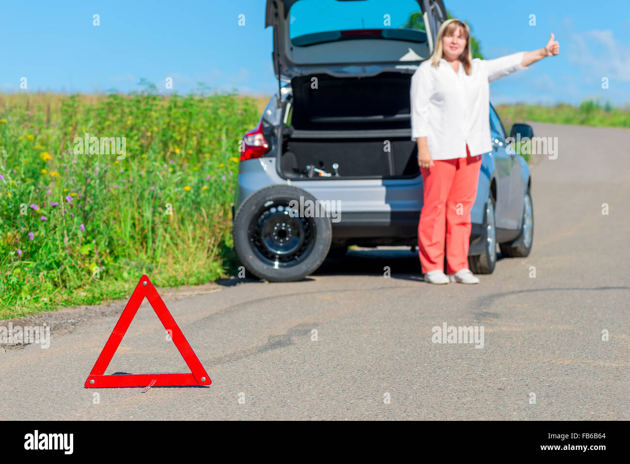 older women asked for help on the road near the broken car Stock Photo