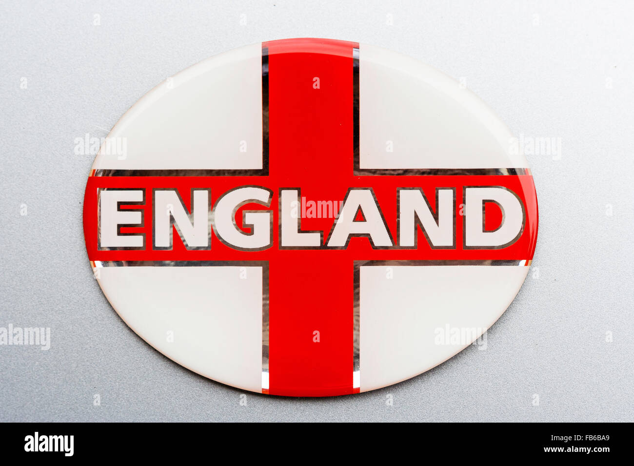 White badge with English flag, (St George), red cross, and the word England across it. Against plain white background. Stock Photo