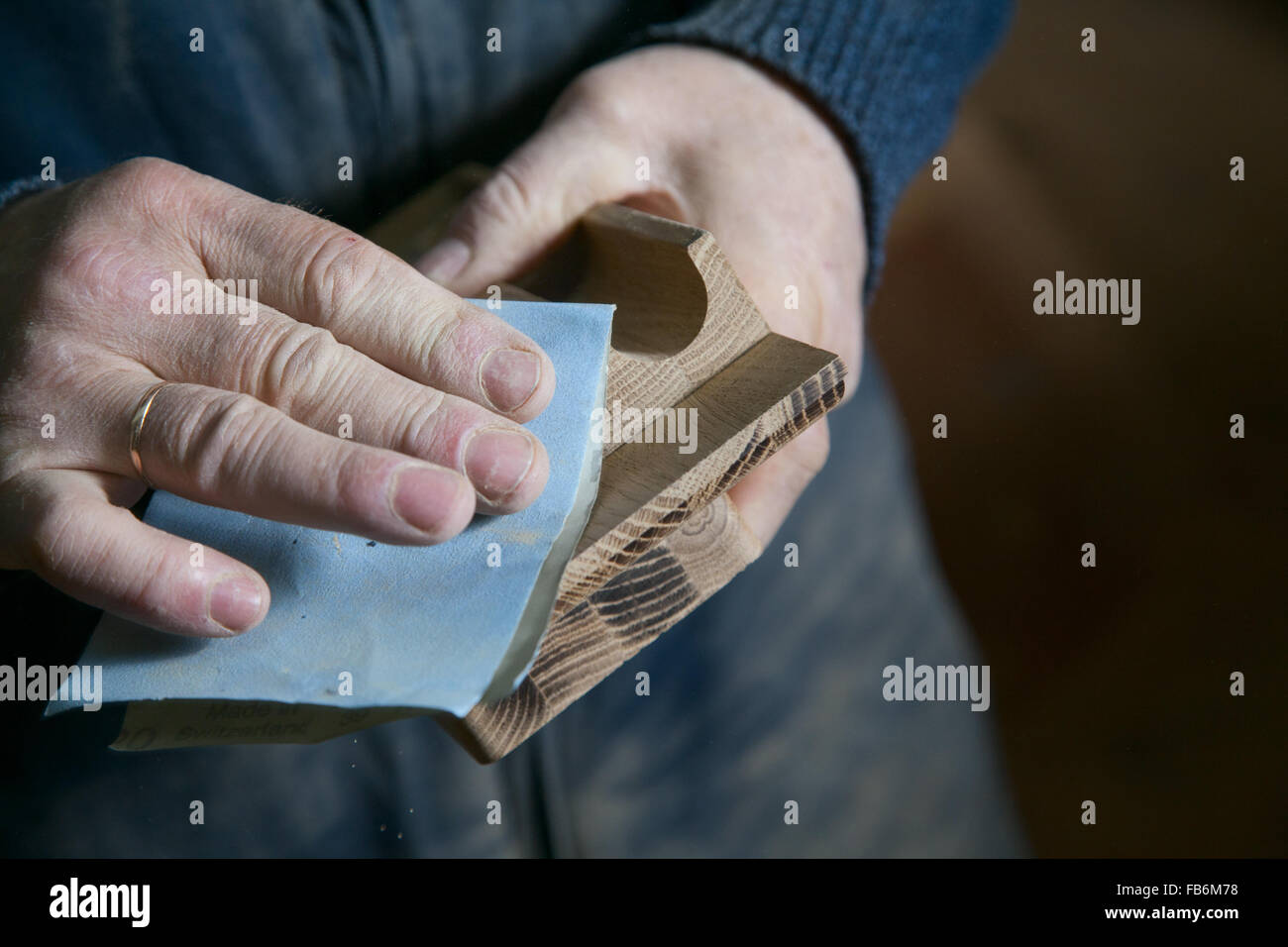 Man sandpaper grinds wood product in the shop Stock Photo Alamy