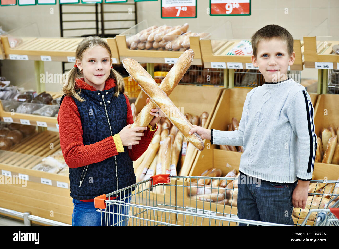Funny children with bread in supermarket Stock Photo