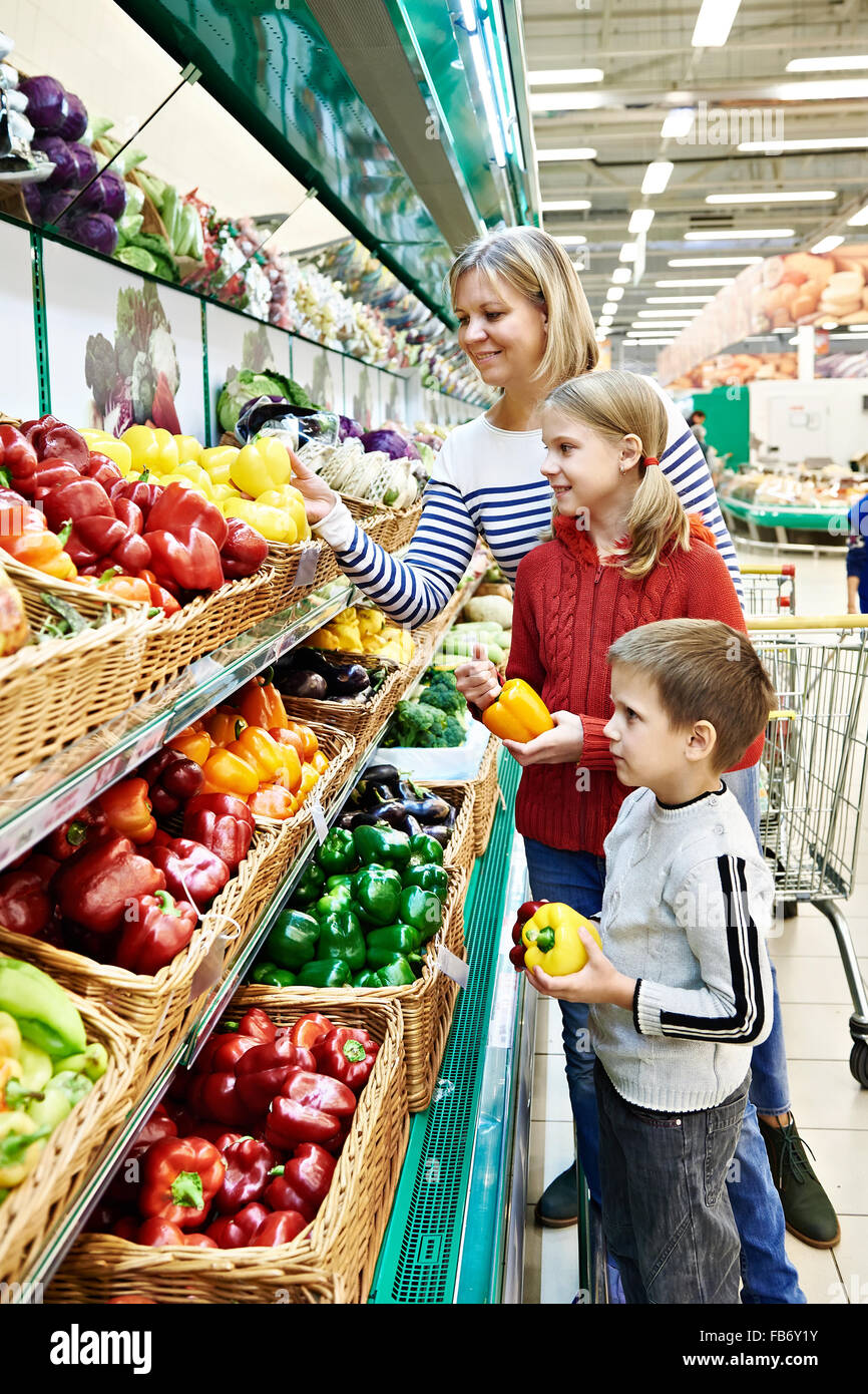 Mother and children with bell pepper in vegetables department in the supermarket Stock Photo