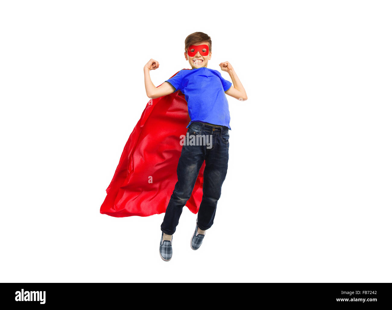 boy in red super hero cape and mask flying on air Stock Photo