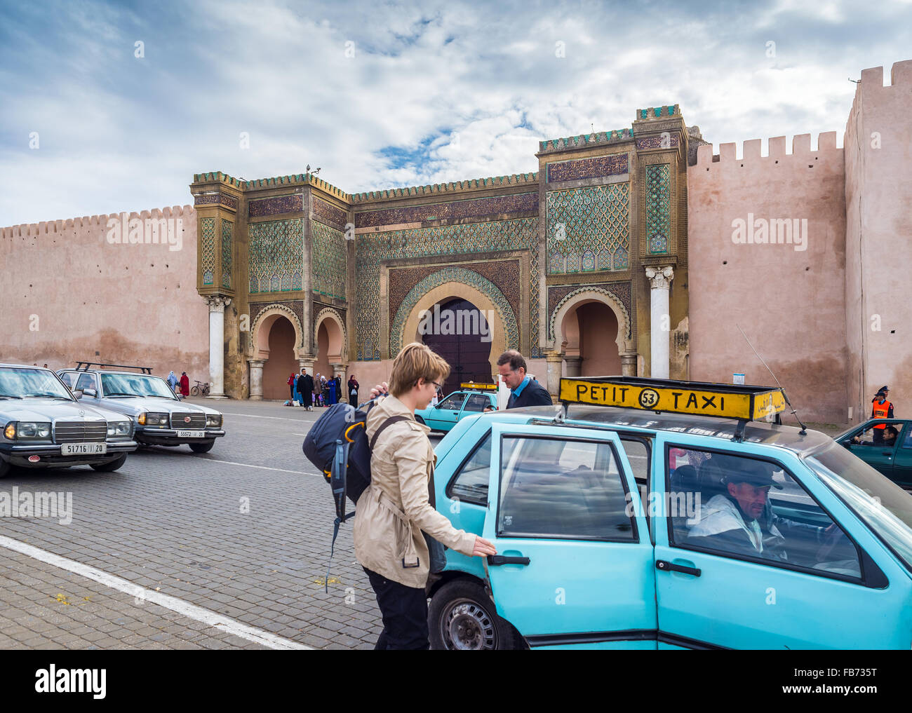 Woman taking a Petit Taxi front of The Bab el Mansour in medina of Meknes. Morocco. Stock Photo