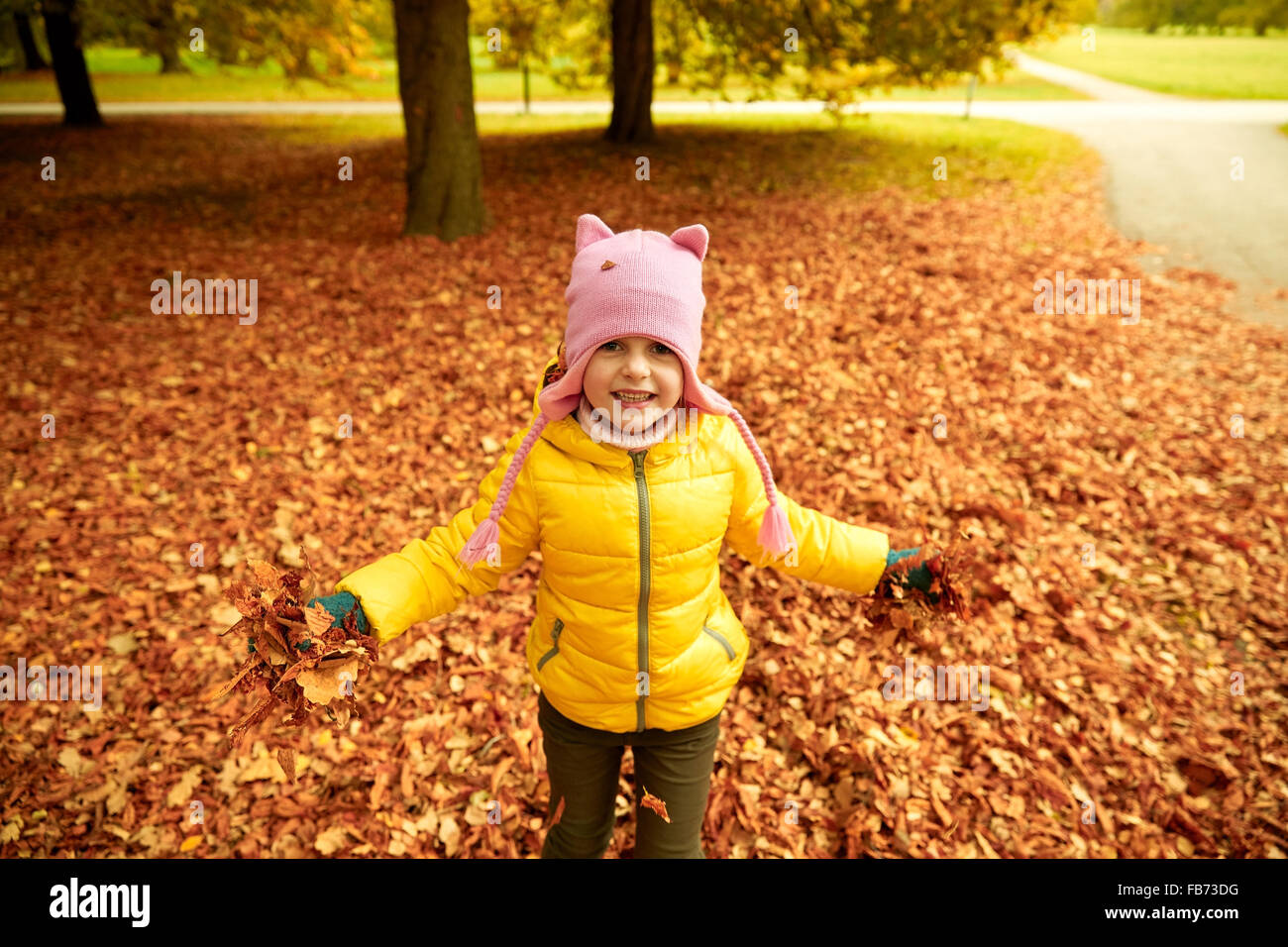 happy girl playing with autumn leaves in park Stock Photo - Alamy