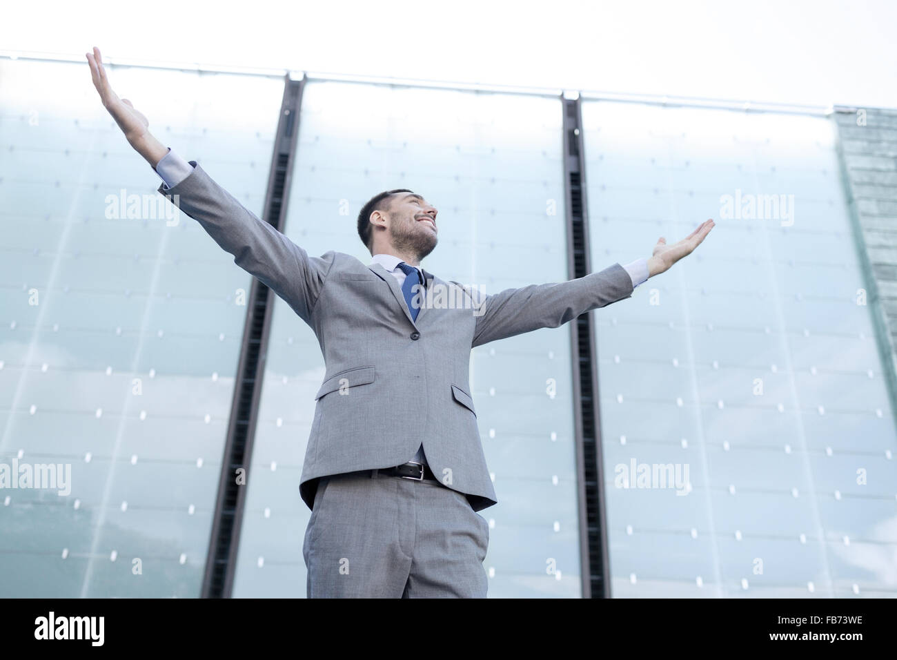 young smiling businessman over office building Stock Photo - Alamy