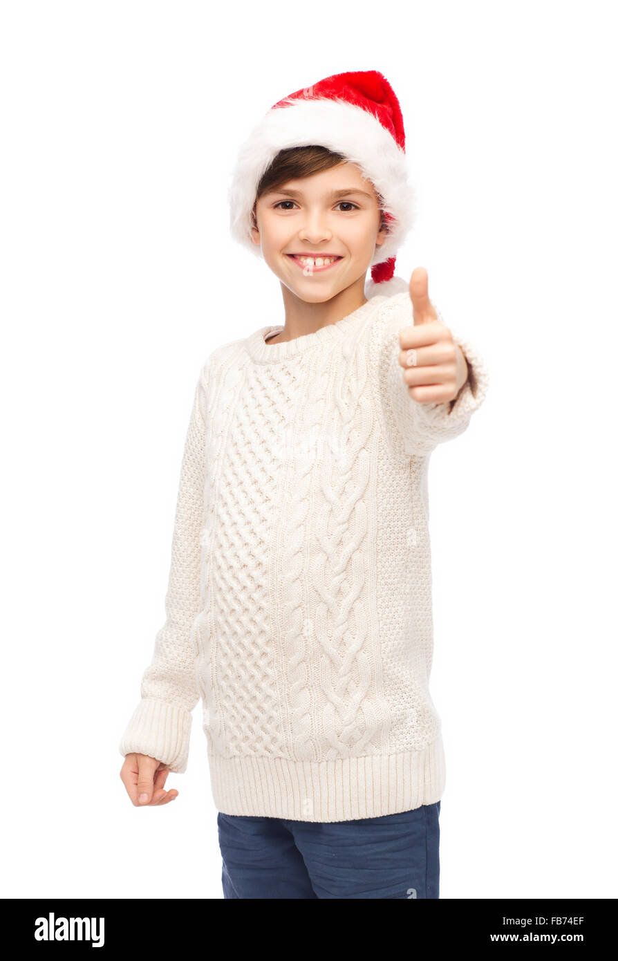 smiling happy boy in santa hat showing thumbs up Stock Photo