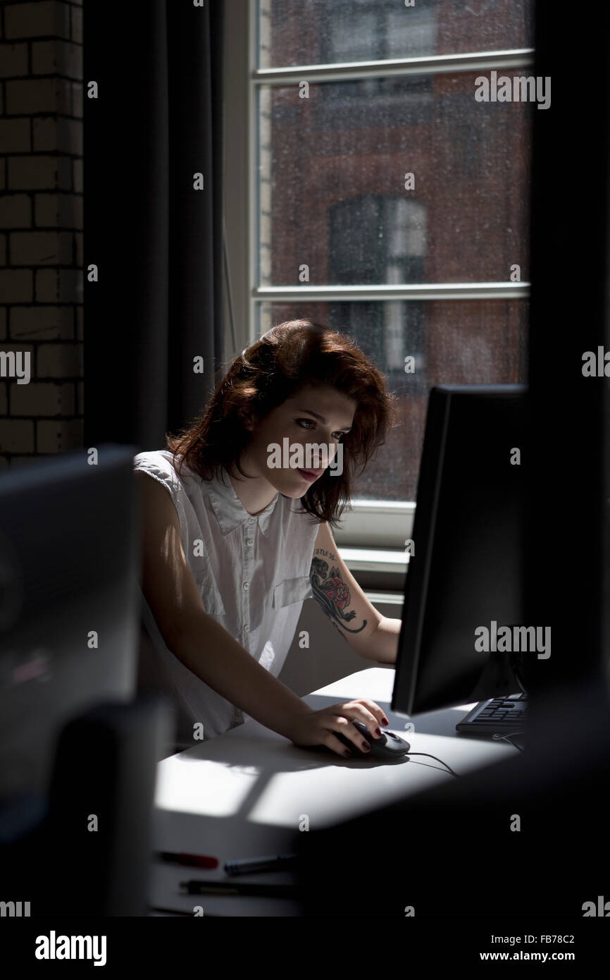 Woman using computer in office Stock Photo