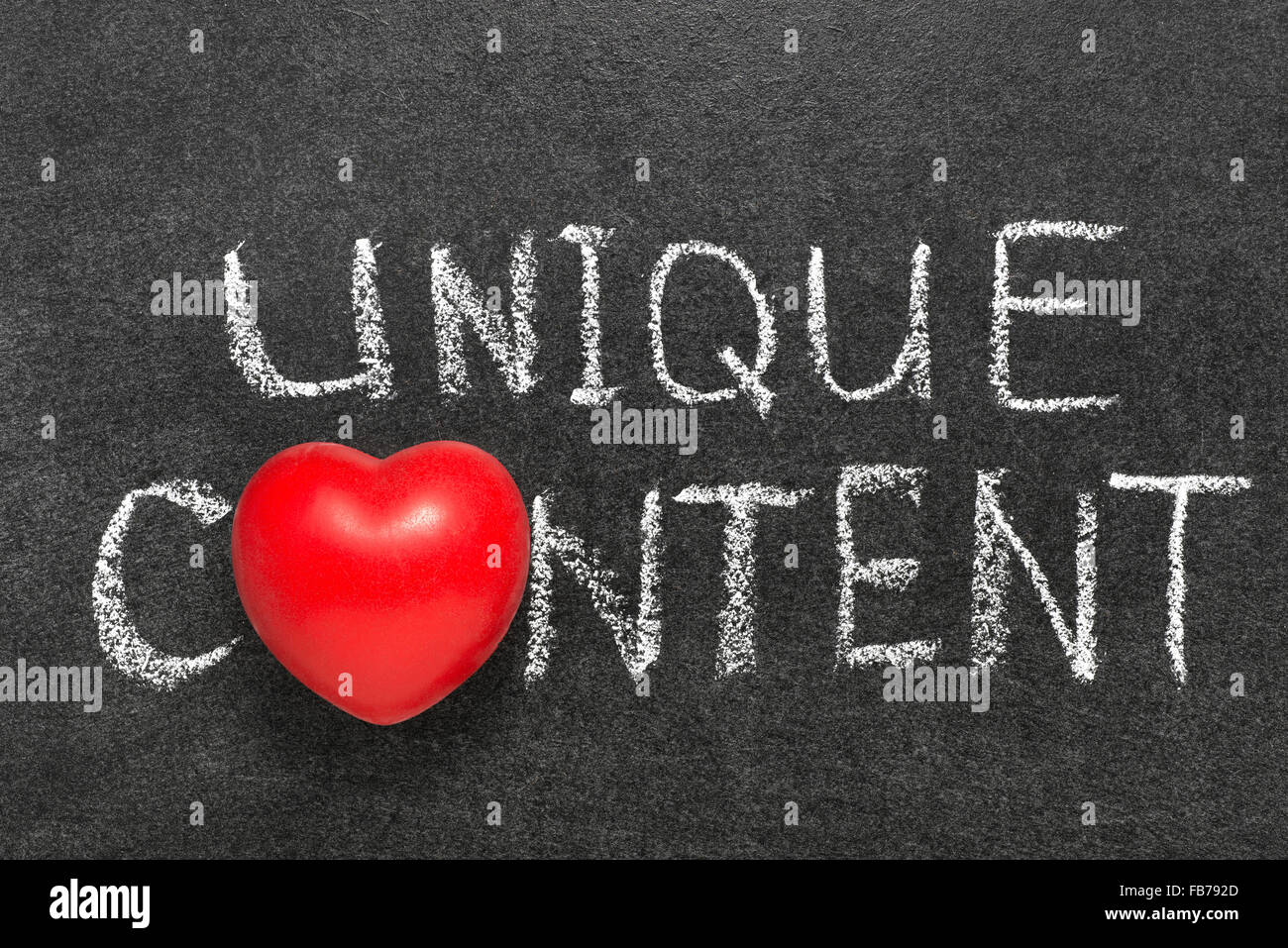 unique content phrase handwritten on blackboard with heart symbol instead O Stock Photo