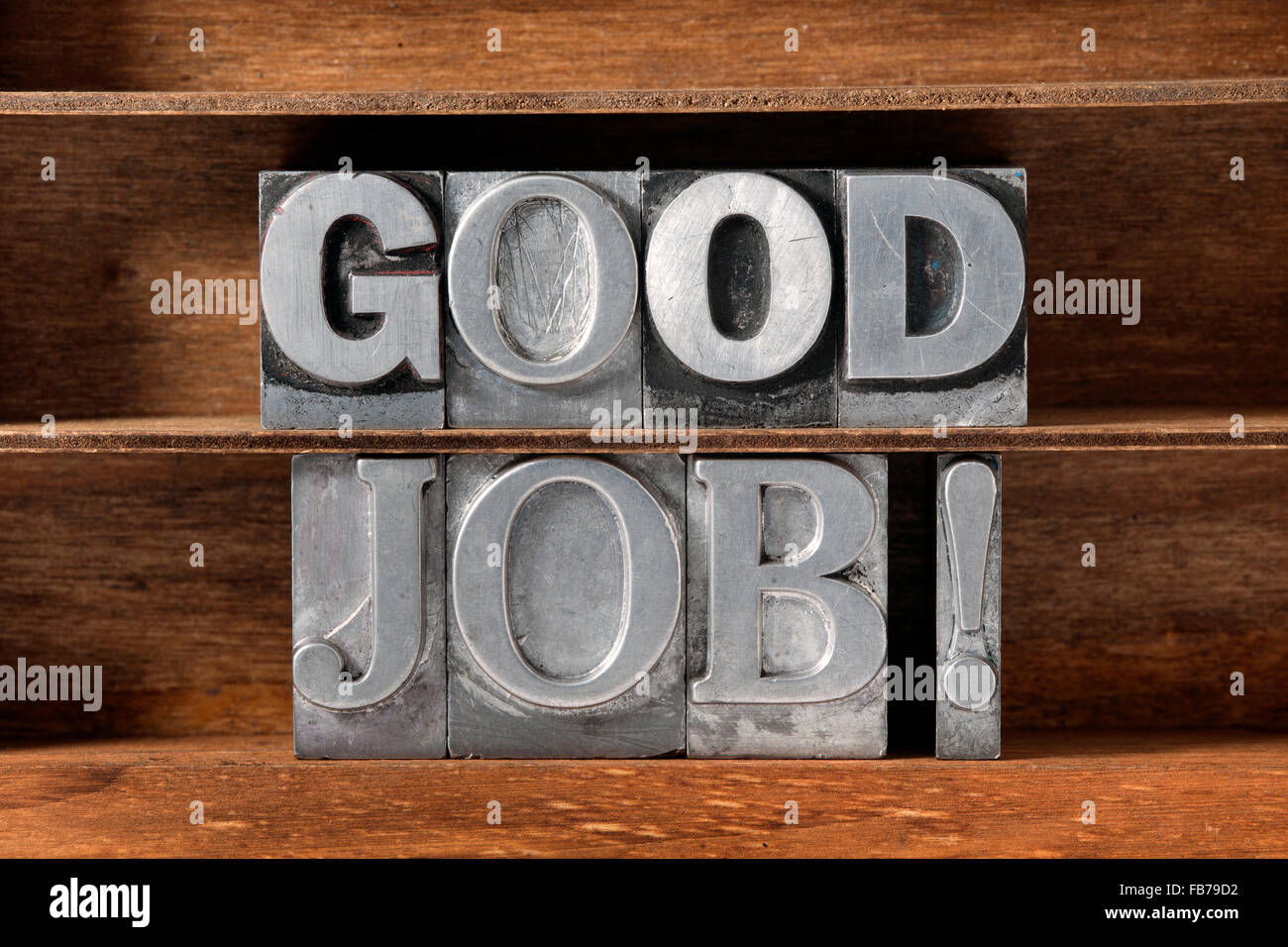 good job exclamation  made from metallic letterpress type on wooden tray Stock Photo