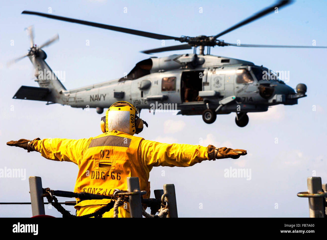 Sikorsky MH-60 Seahawk helicopter, U.S. Navy Petty Officer 3rd Class signals an MH-60S Seahawk helicopter Stock Photo