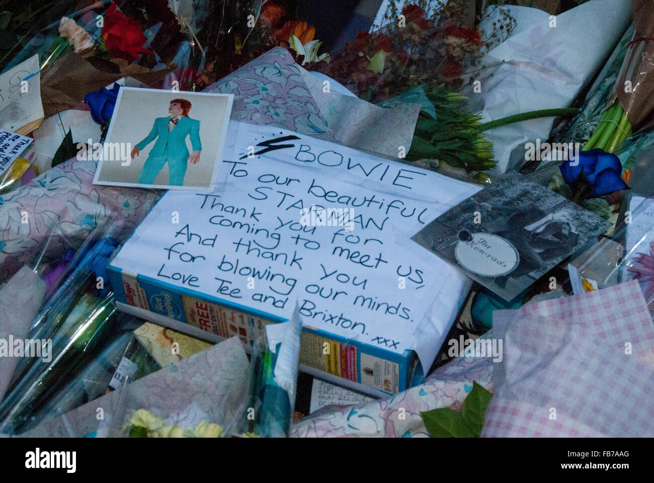 London, UK, 11 January 2016, Crowds gathered and flowers and candles were lit at the mural of David Bowie opposite Brixton tube station. Credit:  JOHNNY ARMSTEAD/Alamy Live News Stock Photo