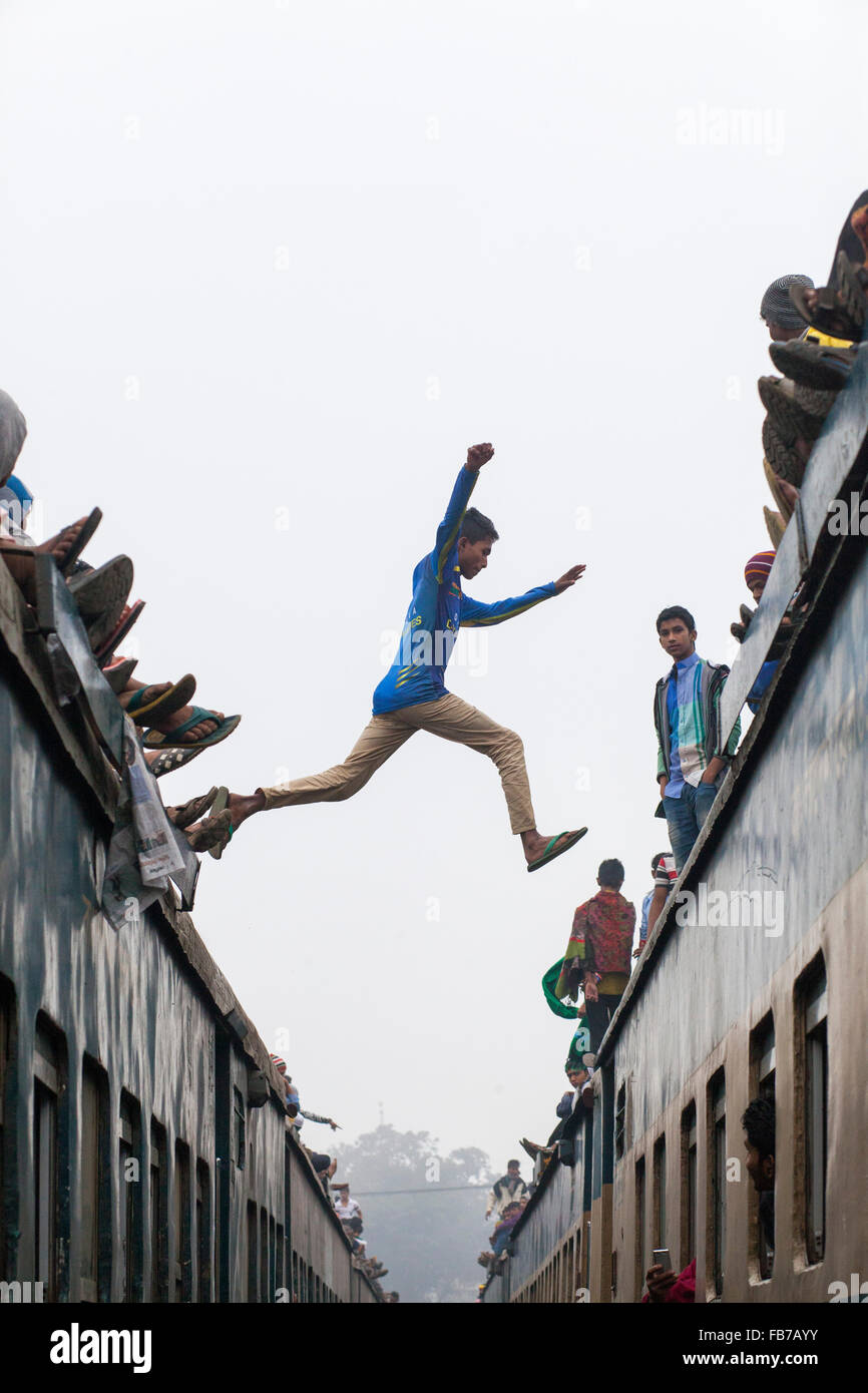 DHAKA, BANGLADESH 10th January 2016: People jumping over crowded train they attend the Akheri Munajat concluding prayers on the third day of Biswa Ijtema, the second largest Muslim congregation after the Hajj, at Tongi Railway station in Tongi 20 km from Dhaka on January 10, 2016. Around two million Muslims from Bangladesh and abroad observed the three-day congregation with prayers on the banks of the Turag River. Stock Photo
