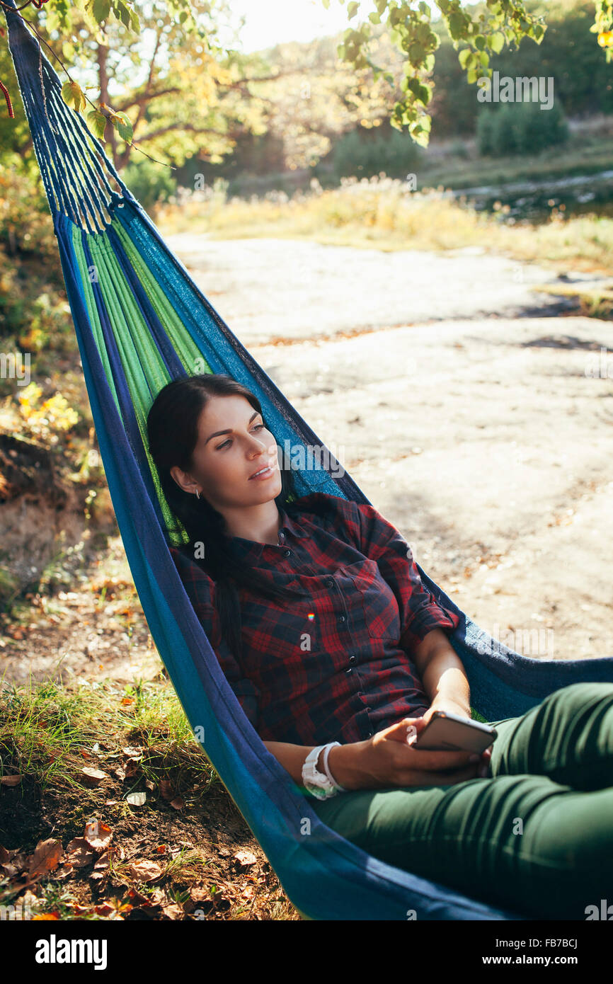 Young hiker resting on hammock in forest Stock Photo