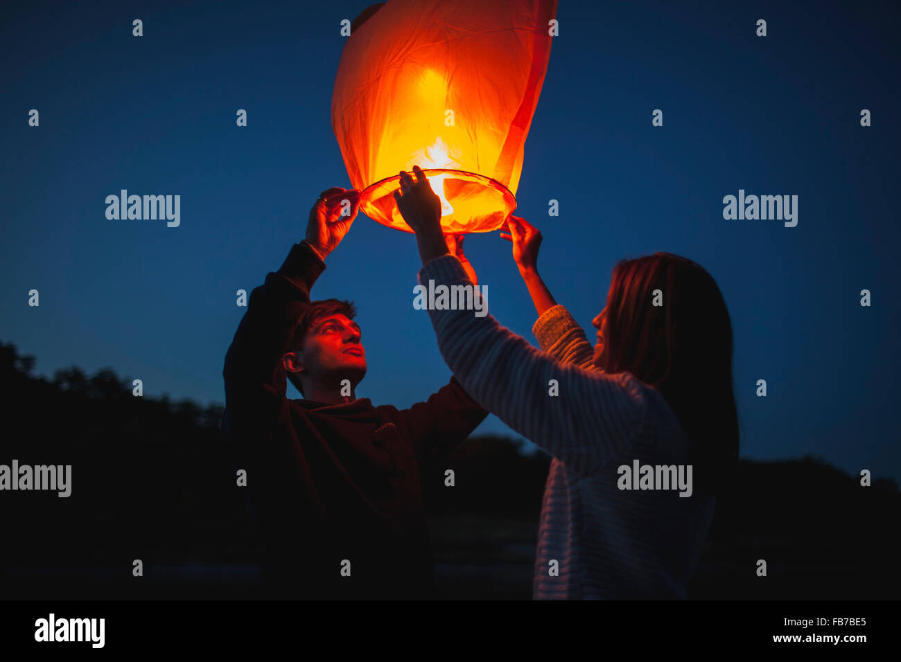 Low angle view of hikers releasing paper lanterns Stock Photo