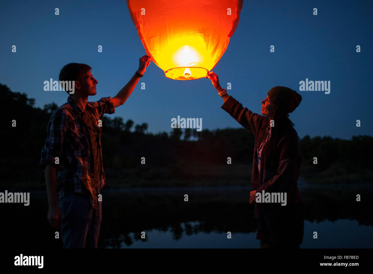 man launching sky lantern into the night sky Stock Photo - Alamy