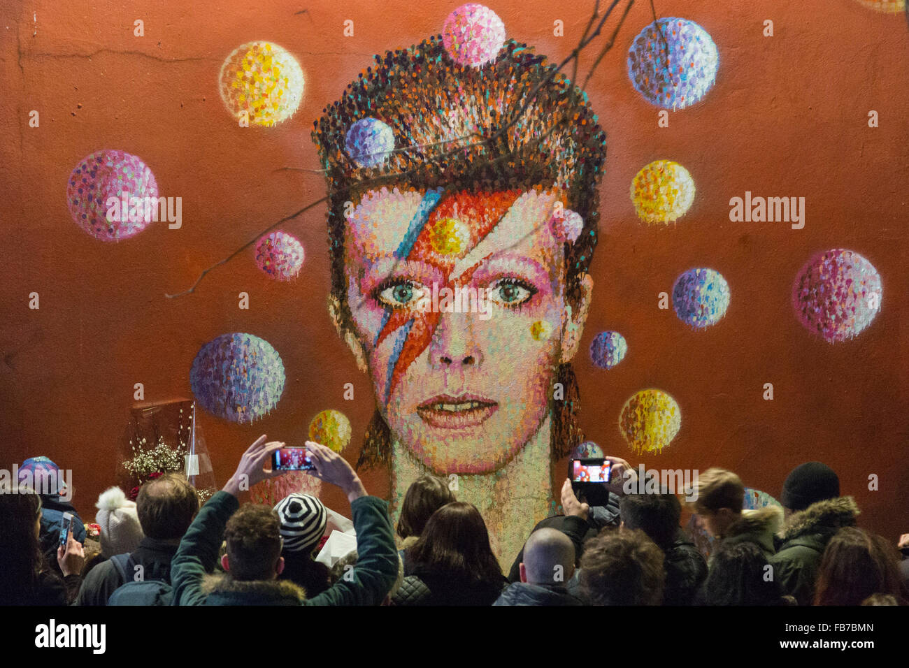 London, UK. 11 January 2016. Fans hold a vigil at the David Bowie mural in Brixton to lay flowers and leave messages. Tributes to David Bowie (1947-2016) who passed away on 10 January 2016. Credit:  Nick Savage/Alamy Live News Stock Photo